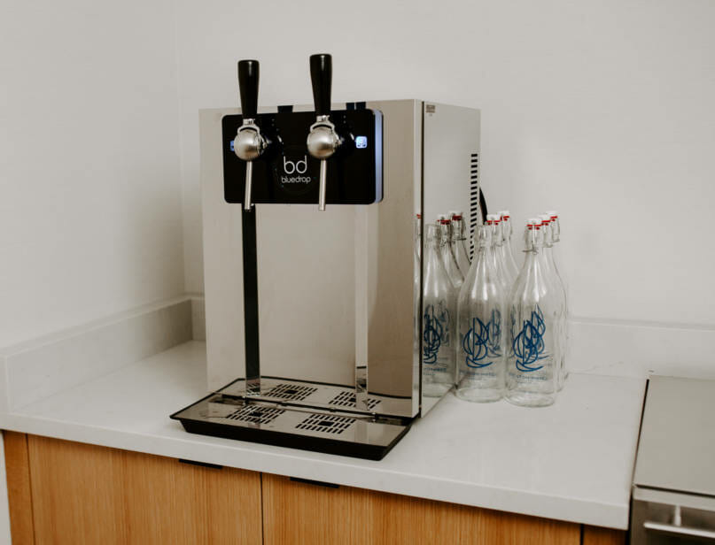 The bar150 bluedrop water system on a counter ready for use.