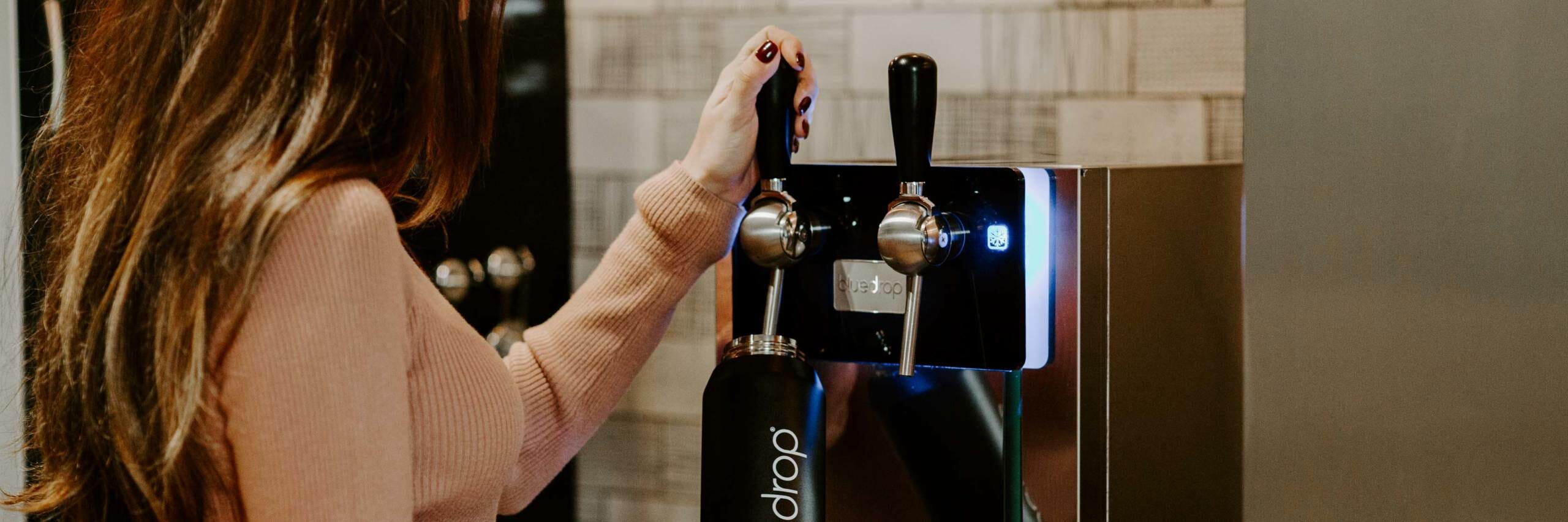 A person filling their water bottle with the Bluedrop product.