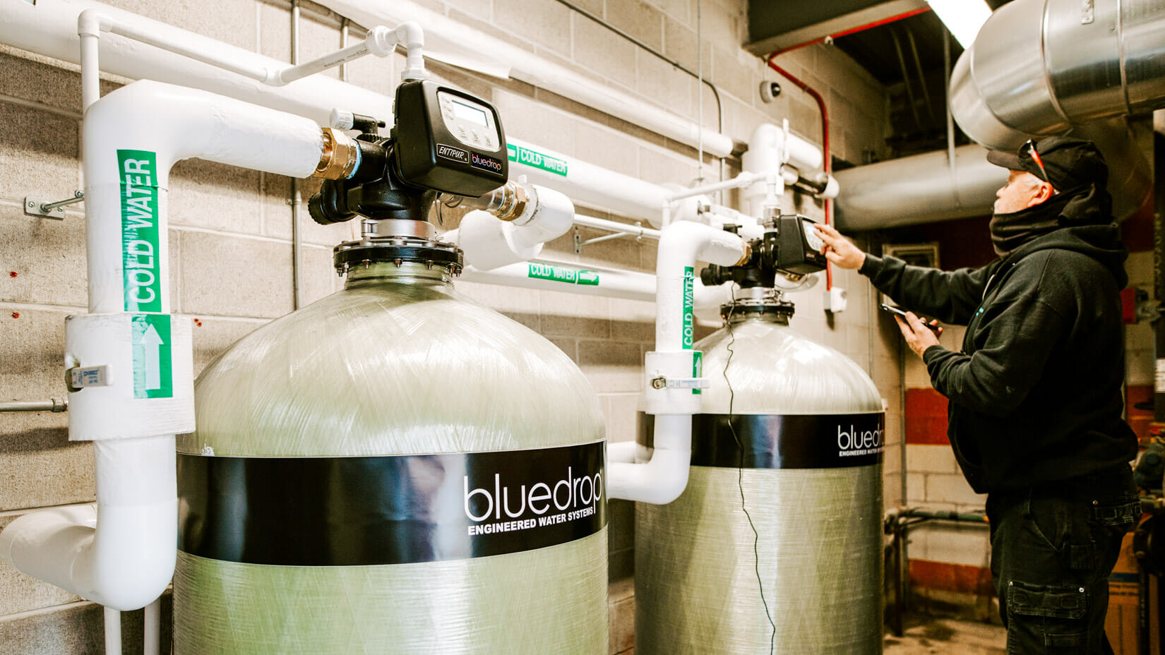 A person adjusting a commercial filtration system