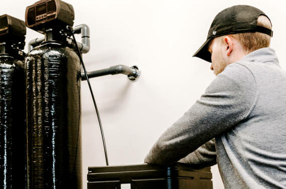 A person adjusting the softener system.