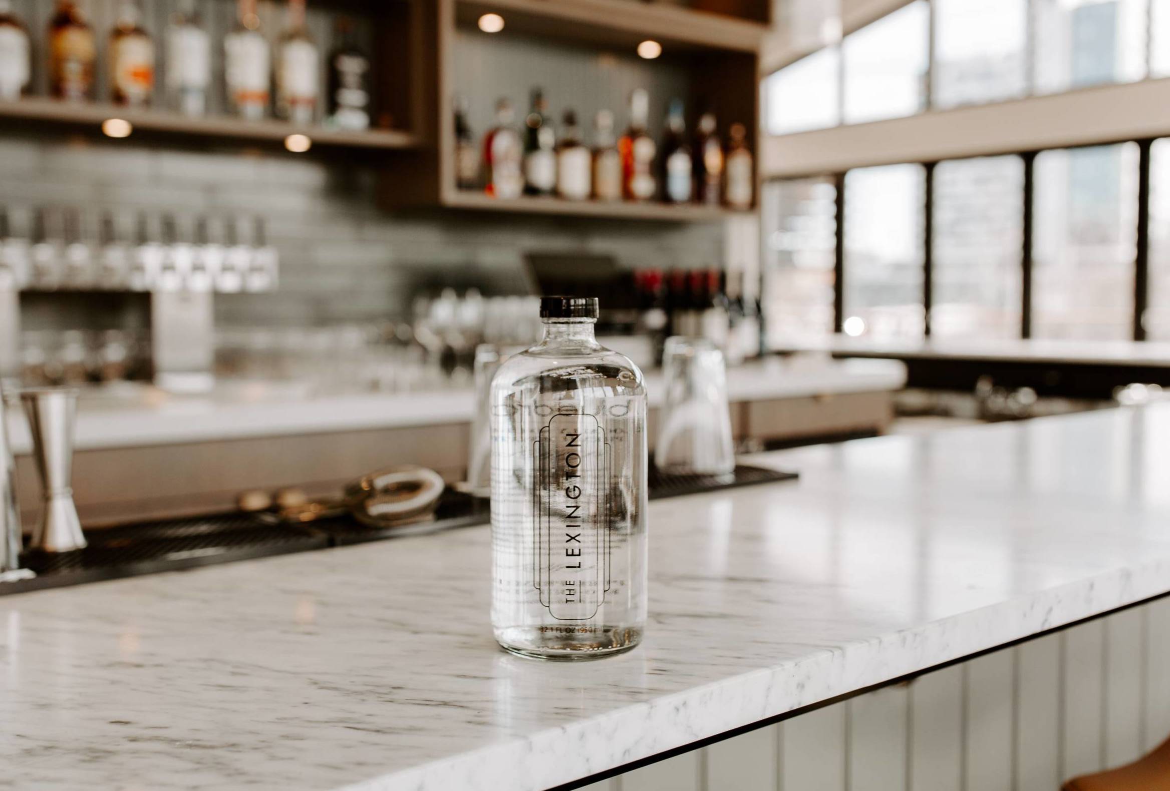 A lexington branded glass bottle on a bar counter.