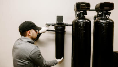A person adjusting their bluedrop water whole home filtration system.