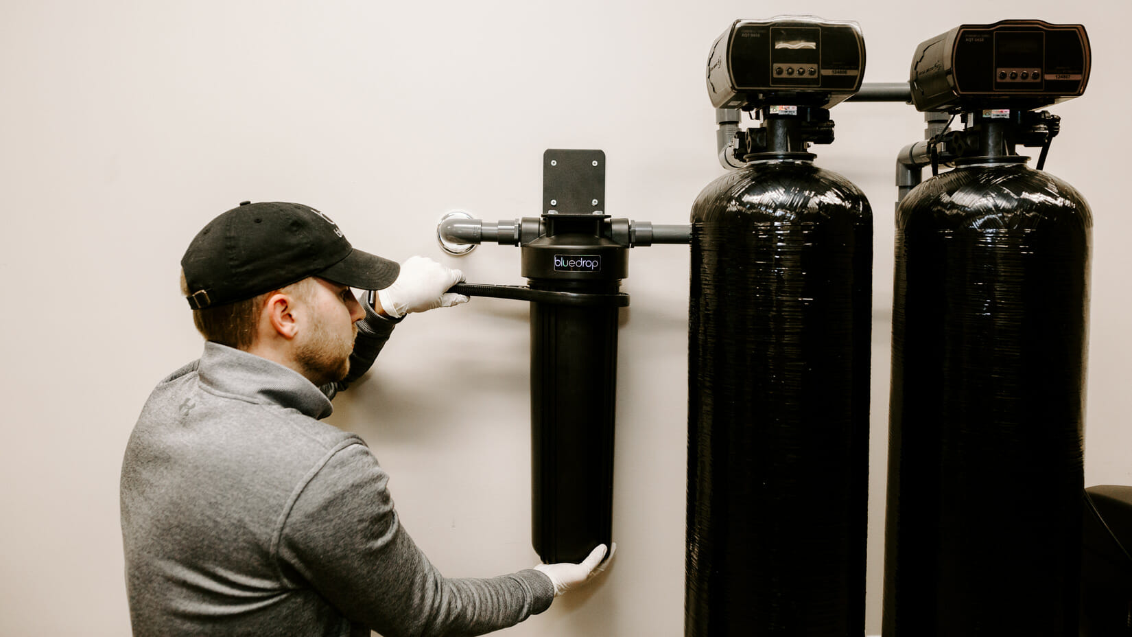 A person adjusting their bluedrop water whole home filtration system.