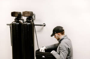 man installing water filtration system