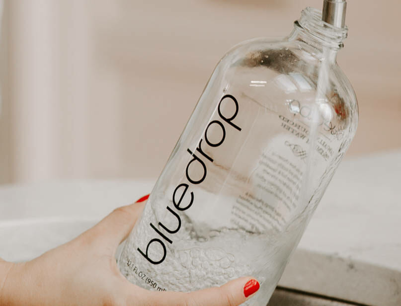 Closeup of a bluedrop water bottle being filled with water.