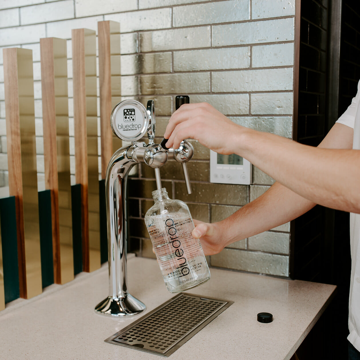 A person using the Tower 2 to fill a water bottle.