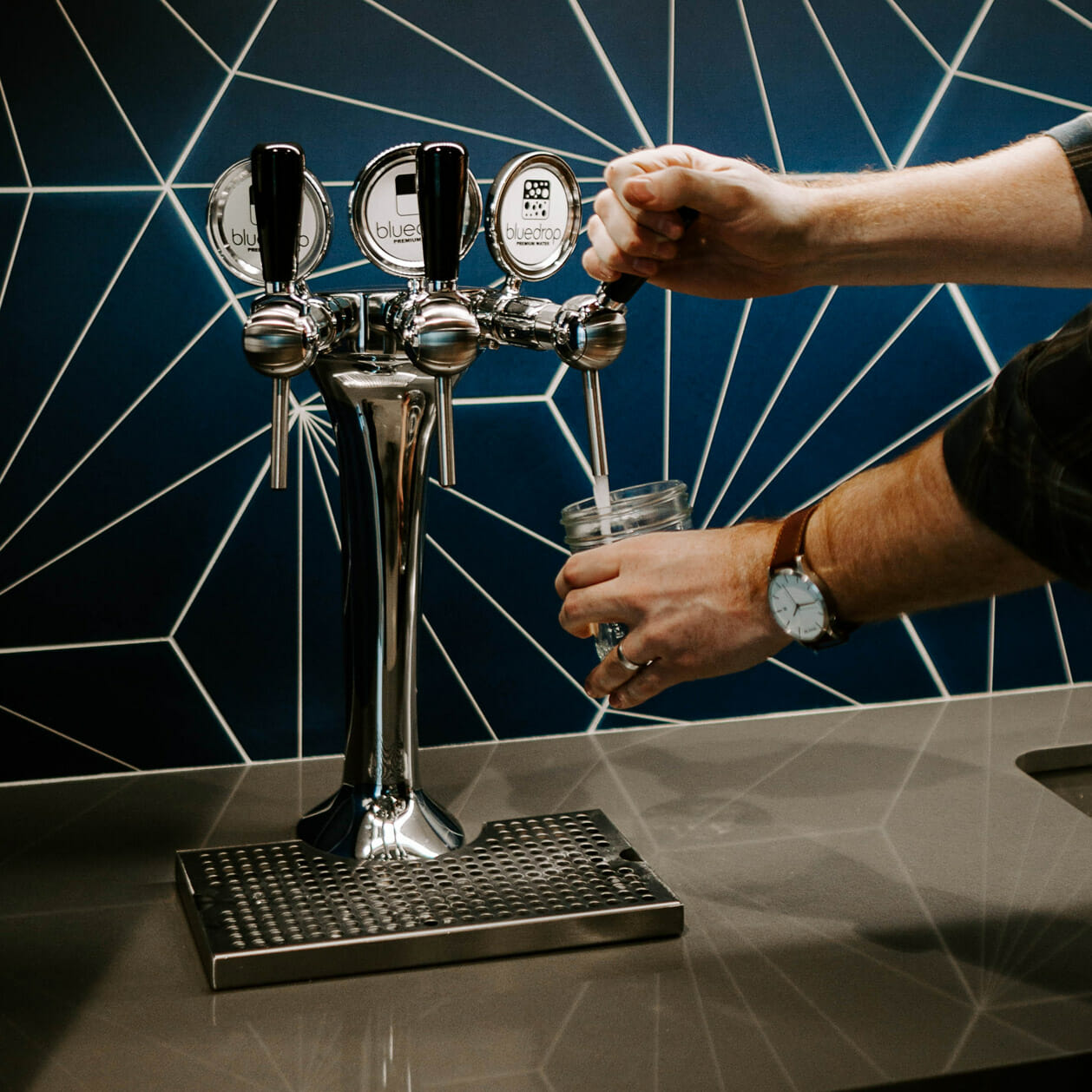 Tower 3 product in use by a person filling up a glass with water.