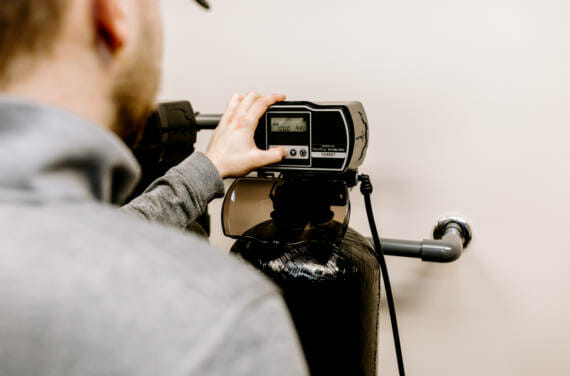 A person adjusting the softener system.