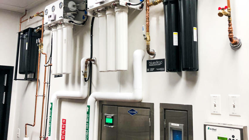 A restaurant water filtration system mounted on a wall.