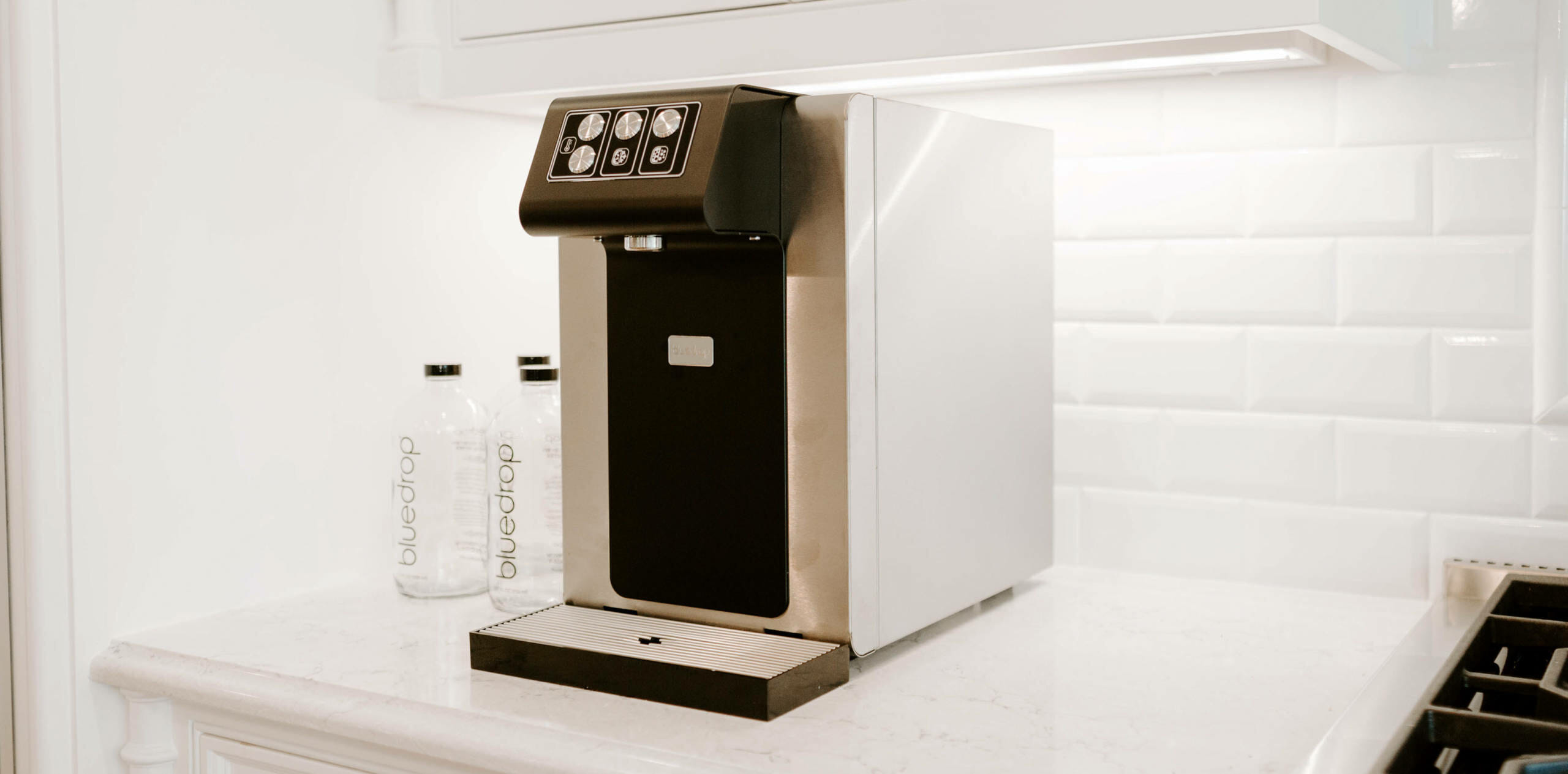 A home kitchen with a still and sparkling water system on the counter top.