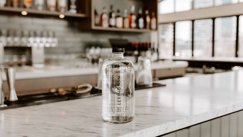 A lexington branded glass bottle on a bar counter.