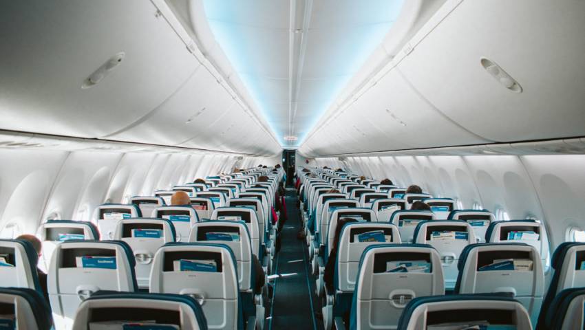 The interior of a plane with rows of seats.
