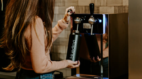 Someone filling their bluedrop water bottle using the bluedrop water product.