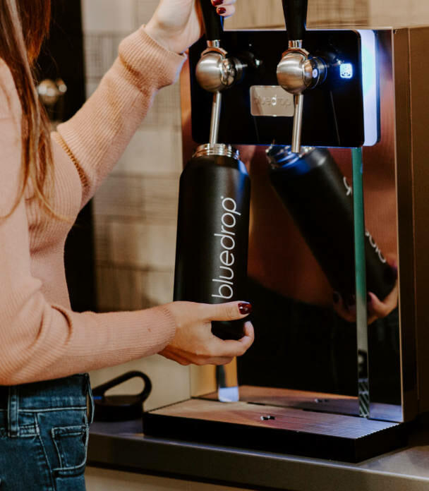 A person filling their water bottle with the Bluedrop product.