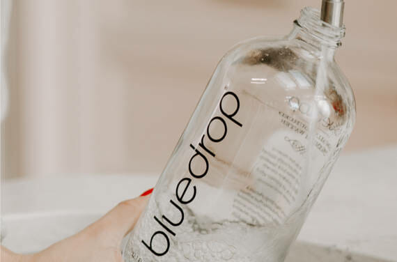 a person filling a bluedrop water bottle.