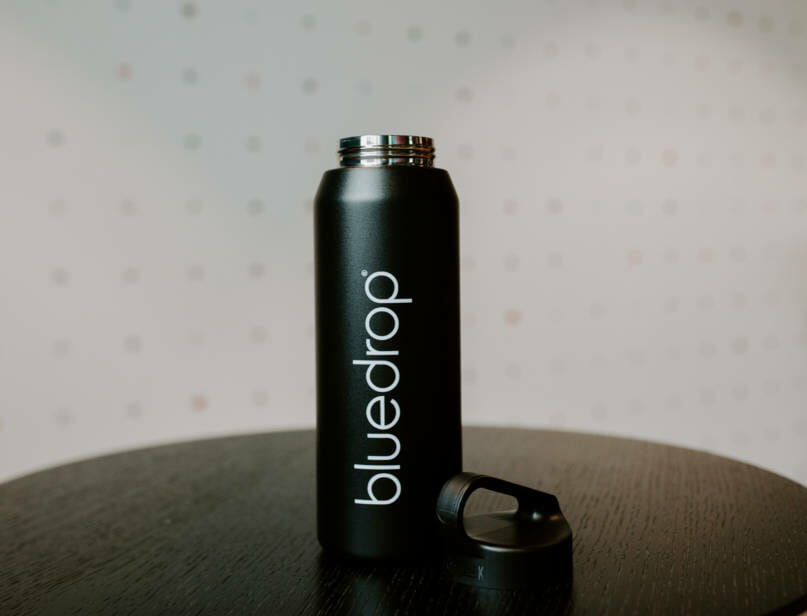 A bluedrop water branded bottle on a table.