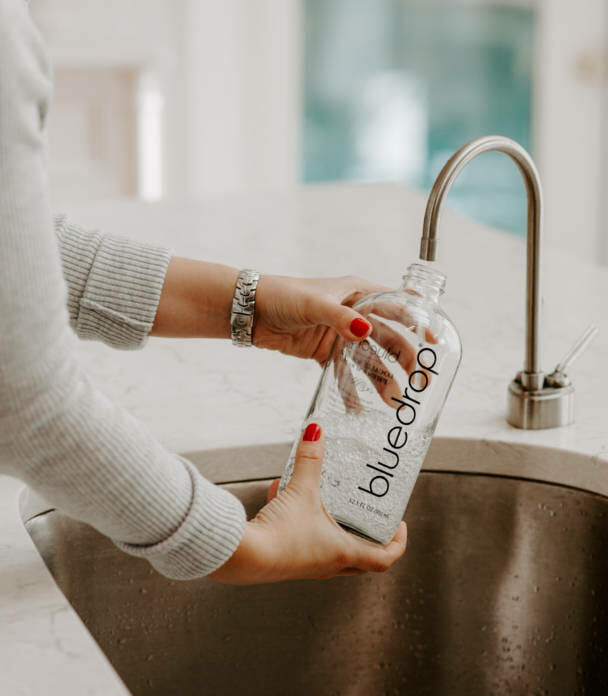 A person filling their water bottle with the Bluedrop product.