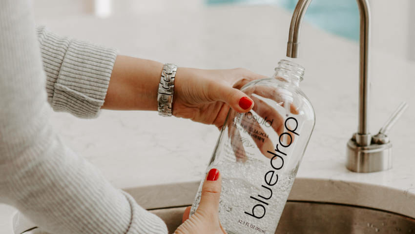 A person filling their water bottle with the Bluedrop product.