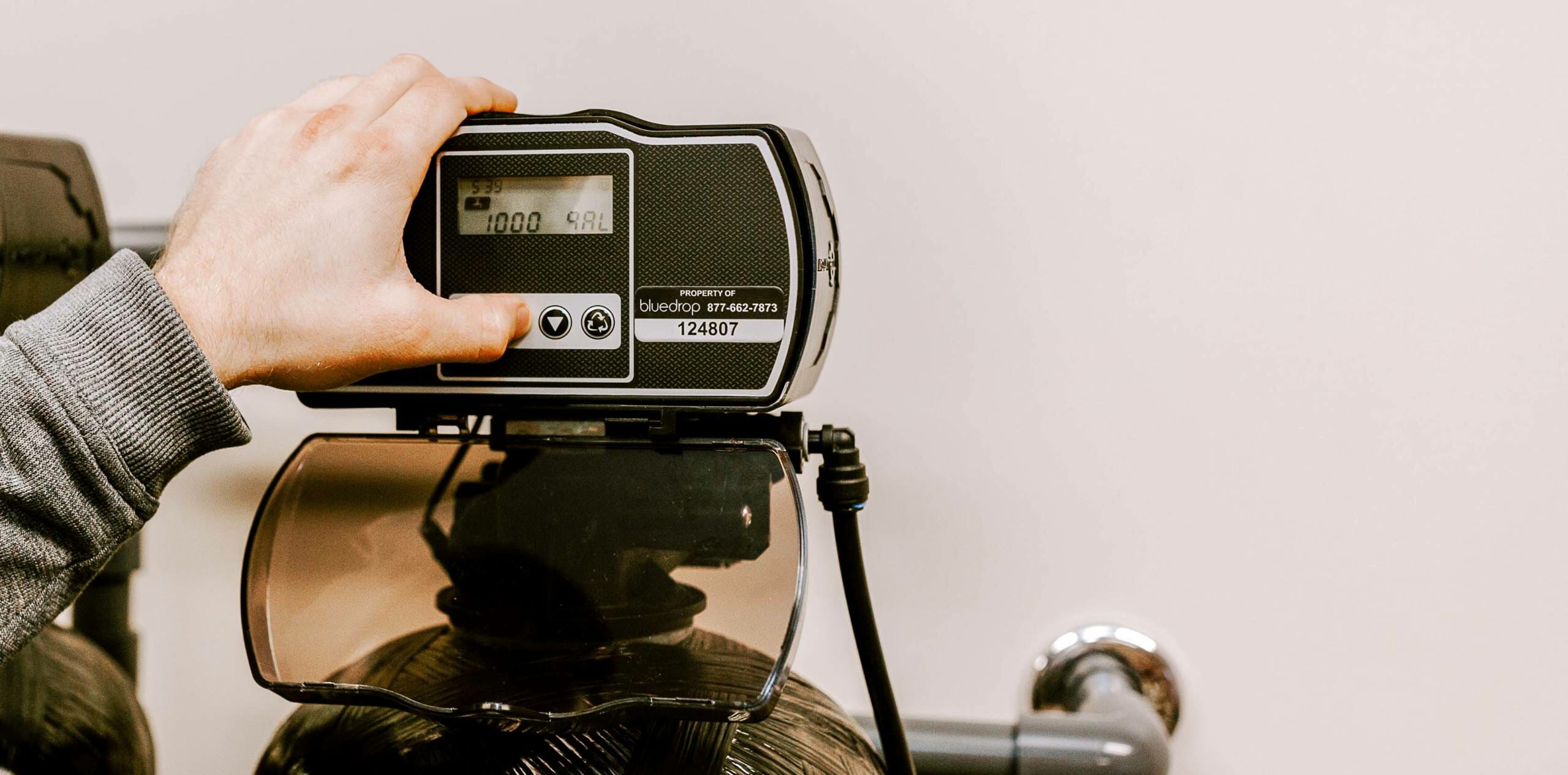 A person adjusting his water softening system in his home.