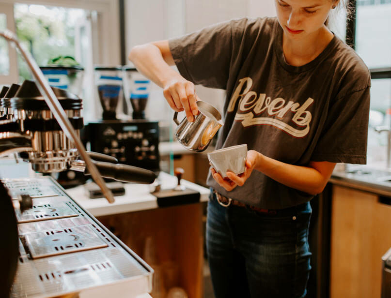 A barista making a latte.