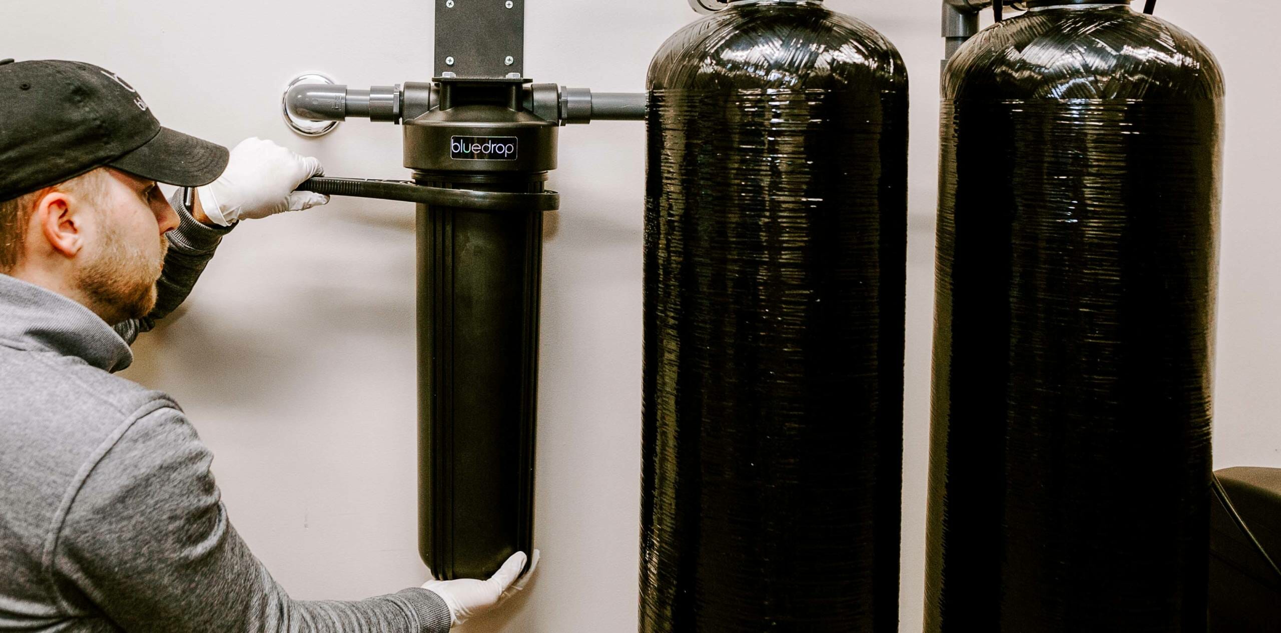 A person adjusting their bluedrop water whole home filtration system.