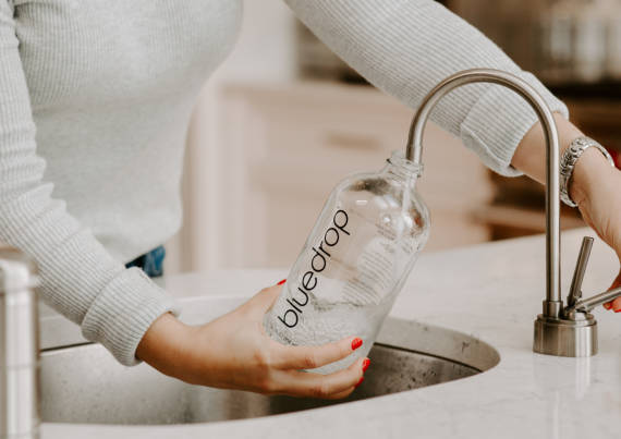 woman filling bottle with bluedrop water