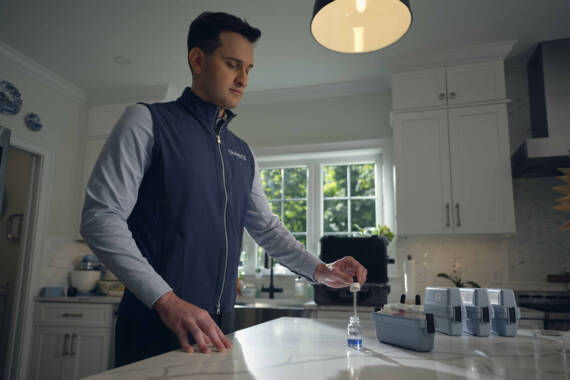 man testing water from tap.